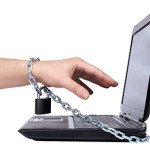Image of a young man's arm chained to a laptop - Internet Addiction