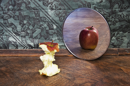 photo of an apple core in front of a mirror with a reflection of a whole apple - body dysmorphic disorder - hired power breakaway