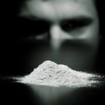 photo of cocaine addicted individual staring at a pile of cocaine - focus on cocaine - breakaway hired power - cocaine nose bleed
