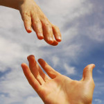 photo of hands reaching out to help one another over a blue cloudy sky background - hired power breakaway