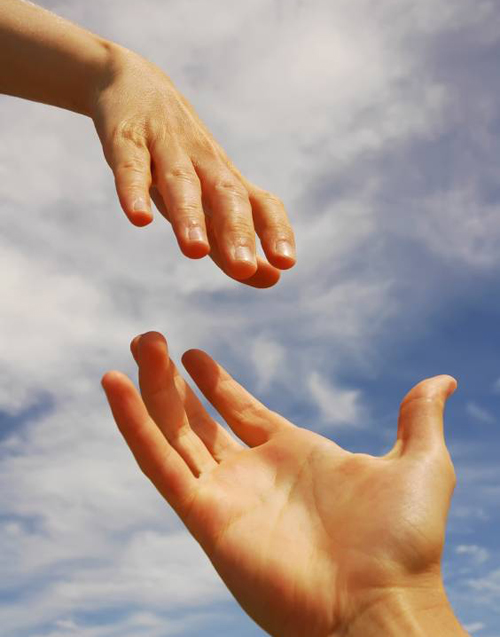 photo of hands reaching out to help one another over a blue cloudy sky background - hired power breakaway